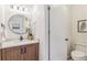 Modern bathroom featuring a stylish vanity with a round mirror, elegant lighting, and a separate toilet area at 5425 Camargo Rd, Littleton, CO 80123