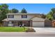 Beautiful two-story home with brick and siding, complemented by a green lawn and mature trees at 5425 Camargo Rd, Littleton, CO 80123