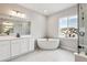 Bright bathroom featuring soaking tub, glass-enclosed shower, double sinks, and large window at 2537 Lupton Ln, Lafayette, CO 80026