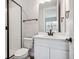 Modern bathroom featuring a glass shower, sleek white vanity with dark accents, and a toilet at 2537 Lupton Ln, Lafayette, CO 80026