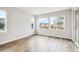 Bright living room with three large windows and beautiful, light wood flooring, with views of the neighborhood at 2537 Lupton Ln, Lafayette, CO 80026