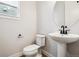 Stylish powder room featuring a pedestal sink, round mirror, and modern black fixtures at 2537 Lupton Ln, Lafayette, CO 80026