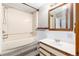 Bathroom featuring a tub, a vanity with a sink and a wood framed mirror at 109 6Th St, Fort Lupton, CO 80621