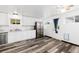 Well-lit kitchen featuring stainless steel appliances, white cabinets, and wood-look flooring at 109 6Th St, Fort Lupton, CO 80621