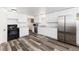 Well-lit kitchen featuring white cabinets, stainless steel appliances, and wood flooring at 109 6Th St, Fort Lupton, CO 80621