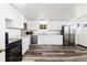 Modern kitchen featuring white cabinets, stainless steel appliances, and wood flooring at 109 6Th St, Fort Lupton, CO 80621