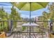 Outdoor patio with table, chairs, umbrella, and view of community buildings and greenery at 5401 S Park Terrace Ave # 301C, Greenwood Village, CO 80111