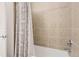 Bright bathroom featuring a bathtub with tile surround and decorative shower curtain at 5401 S Park Terrace Ave # 301C, Greenwood Village, CO 80111