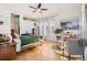 Sunlit bedroom with hardwood floors, ceiling fan, large windows, and seating area with built-in bookcase at 5401 S Park Terrace Ave # 301C, Greenwood Village, CO 80111