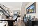 Bright dining area with hardwood floors flows into living room featuring a modern staircase and decorative mountain painting at 2622 W 24Th Ave # 2, Denver, CO 80211