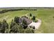 An aerial view showcasing the home, large driveway with basketball court, surrounding acreage, and mature trees at 36412 Paradise Cir, Elizabeth, CO 80107