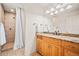Bathroom featuring a granite countertop, wood cabinets, and a walk-in shower with tile surround at 36412 Paradise Cir, Elizabeth, CO 80107