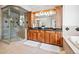 Elegant bathroom featuring a shower, soaking tub, and dual vanity sinks with wood cabinets at 36412 Paradise Cir, Elizabeth, CO 80107