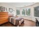 Cozy bedroom featuring beautiful wood floors, large windows with backyard views, and stylish furnishings at 36412 Paradise Cir, Elizabeth, CO 80107