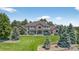 Exterior of a large home with a well-manicured lawn and mature trees at 36412 Paradise Cir, Elizabeth, CO 80107