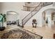 Elegant foyer with a curved staircase, decorative rug, and tile flooring offers a grand entrance at 36412 Paradise Cir, Elizabeth, CO 80107