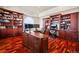 Spacious home office featuring custom wood built-ins, hardwood floors, and abundant natural light at 36412 Paradise Cir, Elizabeth, CO 80107