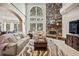 Inviting living room with stone fireplace, tall windows, and neutral decor at 36412 Paradise Cir, Elizabeth, CO 80107