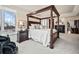 Comfortable main bedroom with a four poster bed, a fireplace, and a window with a scenic view at 36412 Paradise Cir, Elizabeth, CO 80107