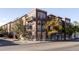 Attractive exterior view of an apartment building with balconies, windows and mature trees at 1489 Steele St # 104, Denver, CO 80206