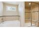 Bright bathroom featuring a glass-enclosed shower, a bathtub, and tile surround at 5755 S Fulton Way, Greenwood Village, CO 80111