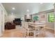 Open-concept living and dining area featuring a stone fireplace and hardwood floors at 5755 S Fulton Way, Greenwood Village, CO 80111