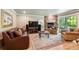 Comfortable living room featuring a stone fireplace, large TV, and plush seating at 5755 S Fulton Way, Greenwood Village, CO 80111