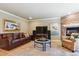 Inviting living room with a leather sofa, fireplace, and a large television for entertainment at 5755 S Fulton Way, Greenwood Village, CO 80111