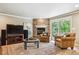 Cozy living room with a stone fireplace, comfortable seating, and a sliding door to the outside at 5755 S Fulton Way, Greenwood Village, CO 80111