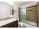 Bathroom with glass-enclosed shower and sliding door, marble countertops, and a wood vanity at 1662 S Everett St, Lakewood, CO 80232