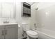 A bathroom with white tile, tub and shower, grey vanity, and mounted medicine cabinet at 13393 E Louisiana Ave, Aurora, CO 80012