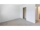 A neutral bedroom showcases a closet and a peek into the hallway at 13393 E Louisiana Ave, Aurora, CO 80012