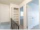 Hallway with storage shelves, neutral carpet, and a doorway to a bedroom at 13393 E Louisiana Ave, Aurora, CO 80012