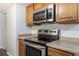 Close up shot showcasing a stainless steel oven and microwave, and wood cabinetry at 13393 E Louisiana Ave, Aurora, CO 80012