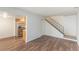 A warm open-concept space with sleek floors leading to a kitchen and an iron stair railing at 13393 E Louisiana Ave, Aurora, CO 80012