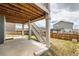 Backyard under the deck featuring a staircase and views of the fenced in lawn area at 935 Peach Leaf Ln, Elizabeth, CO 80107