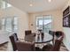 Cozy dining area features a round wooden table, plush chairs, and sliding glass doors to a balcony at 935 Peach Leaf Ln, Elizabeth, CO 80107
