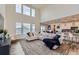 Open-concept living room with large windows, light-colored walls, and comfortable seating perfect for entertaining at 935 Peach Leaf Ln, Elizabeth, CO 80107