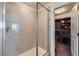 Modern tiled shower with glass door and a peek into a walk-in closet filled with shoes at 935 Peach Leaf Ln, Elizabeth, CO 80107