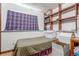 This basement is well lit by a window and has a bed, pillows, and shelves at 11599 Kendall St, Westminster, CO 80020