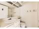 Simple bathroom featuring a white vanity, toilet, and a large mirror at 1100 S Waco St # D, Aurora, CO 80017