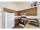 Well-lit kitchen with wooden cabinets, white appliances, and double sink at 1100 S Waco St # D, Aurora, CO 80017