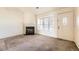 Cozy living room with a fireplace, carpeted floors and ample natural light from a window at 1100 S Waco St # D, Aurora, CO 80017