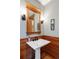 A modern bathroom with a pedestal sink, stylish lighting, and traditional wood trim at 1143 S Saint Paul St, Denver, CO 80210