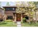 Charming two-story brick home with a meticulously landscaped front yard, covered porch and mature trees at 1143 S Saint Paul St, Denver, CO 80210