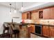 Basement wet bar features wooden cabinets, granite countertops, wine storage, and modern lighting at 1143 S Saint Paul St, Denver, CO 80210