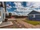 A spacious backyard features a detached garage, patio with a table and chairs, decorative rocks, and a fenced perimeter at 55490 E 27Th Pl, Strasburg, CO 80136