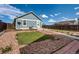 Backyard features a detached garage, a patio with chairs, artificial turf patches, decorative rocks, and wood perimeter fencing at 55490 E 27Th Pl, Strasburg, CO 80136