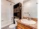 This bathroom features a shower and tub, a vanity, and storage space at 55490 E 27Th Pl, Strasburg, CO 80136