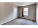 This bedroom features plush carpeting, a window with natural light, and neutral paint colors at 55490 E 27Th Pl, Strasburg, CO 80136